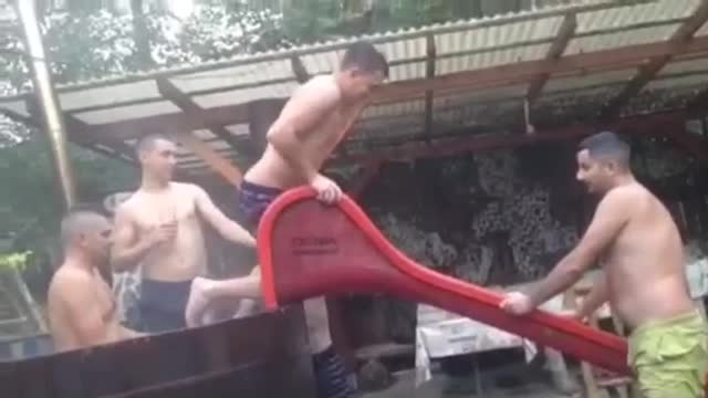 Guy goes down red slide face first into grass