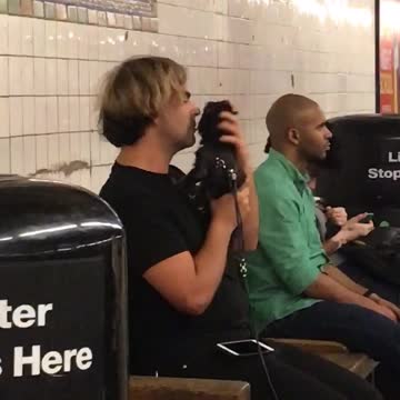 Man short hair blonde kissing black dog black outfit