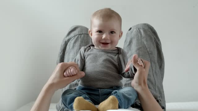 Baby on the belly of his mother plays and smiles