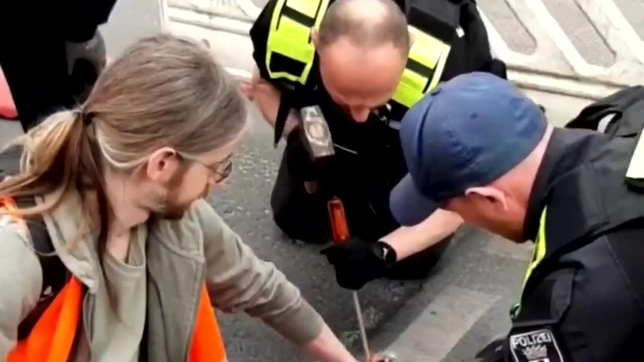 Police have to use HAMMERS to unglue the hands of a climate change activist