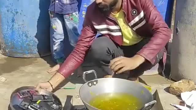 An adult pranking a kid by putting his phone in oil to transform it to new ones