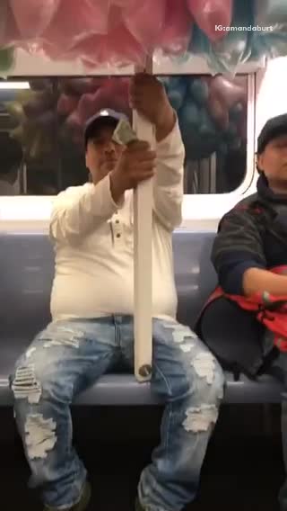 Man on subway with stick pole full of cotton candy