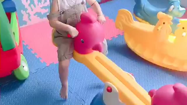 2 babies playing seesaw happily