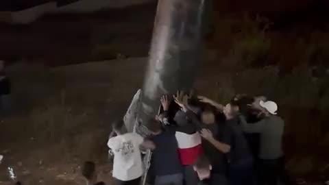 People on the Westbank Pose with Shot-Down Iranian Missile