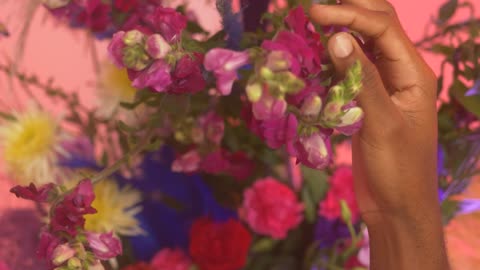 Hand of an LGBTQ man stroking flowers