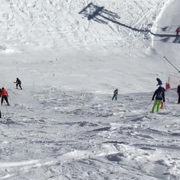 Girl in all black skis down snow slope