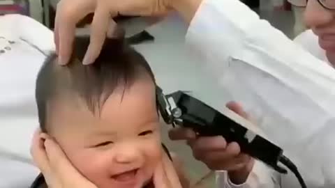 baby's extremely excited while receiving a haircut