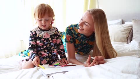 Mom Talking to Her Daughter While Her Child Draws on the Sketchpad