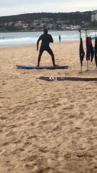 Man in black wet suite practicing on surf board