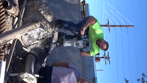 Daniel Thayer jack hammering the concrete from flag pole