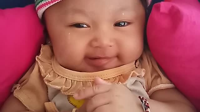 Little girl laughing funny on the pushchair.