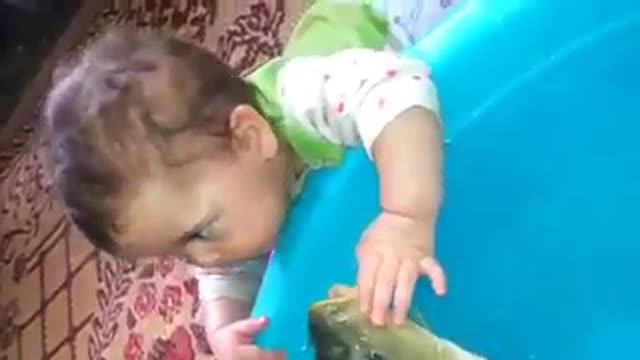 small baby play with fish with water