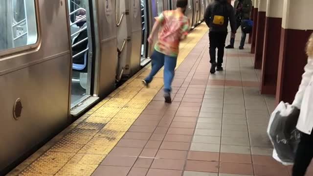 Man colorful shirt jumps out of subway train