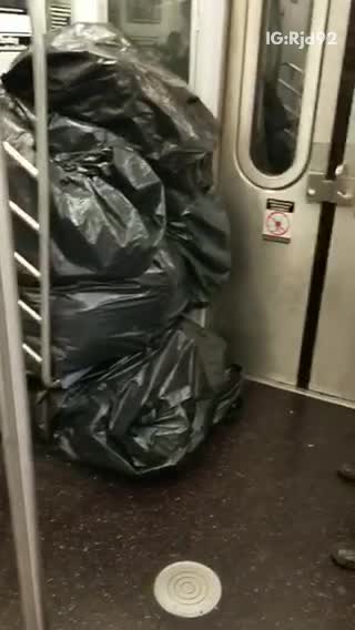 Black trash piled up man in cardboard boxes
