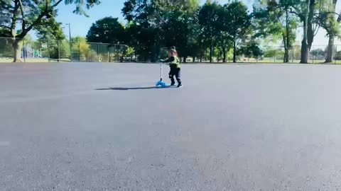 Little kid riding scooter