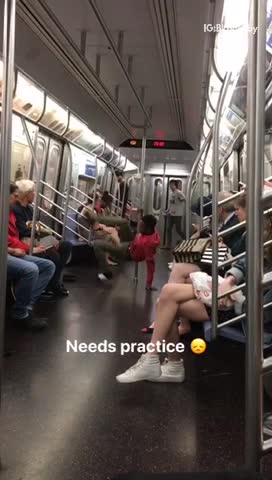 Guy red sweater dancing pole subway needs practice