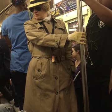 Old man in glasses and trench coat on train
