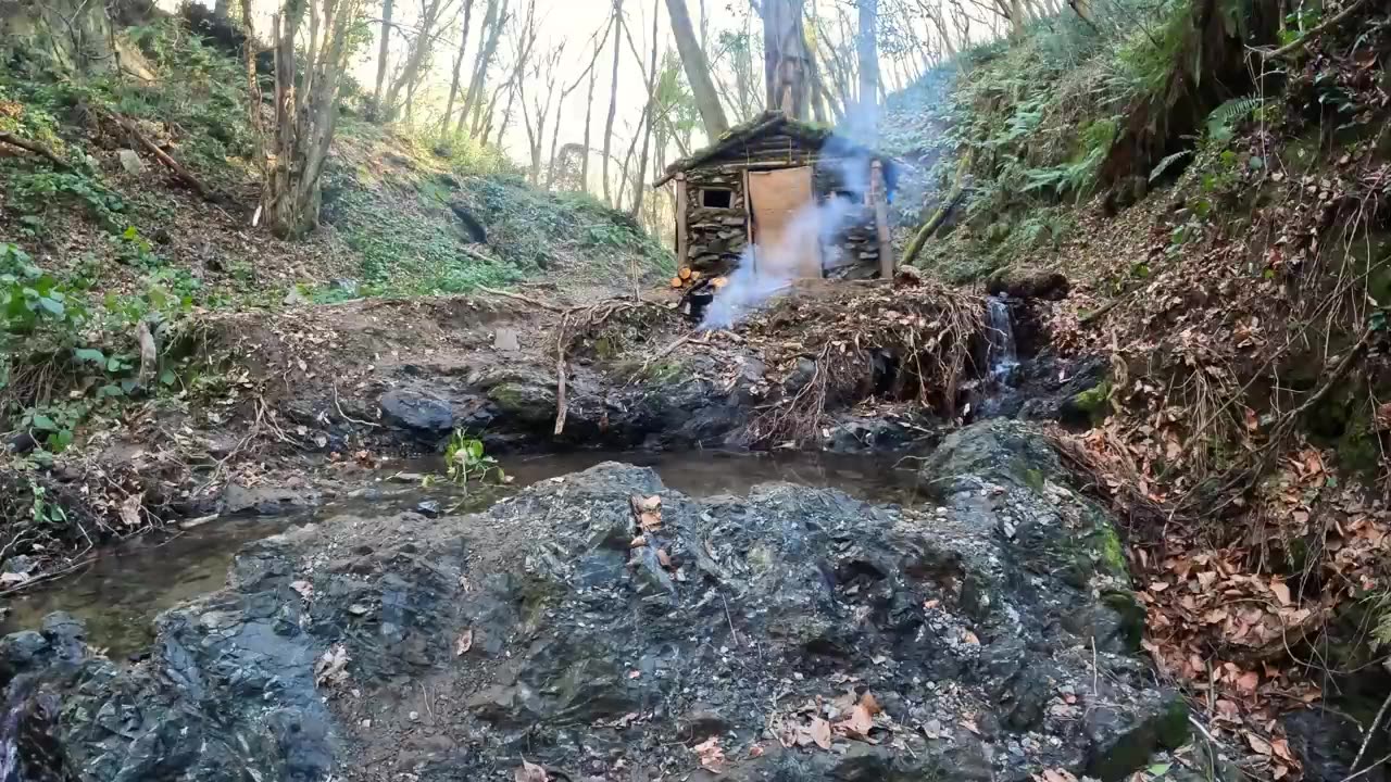 Survival in the forest, building a house from a tree near a waterfall