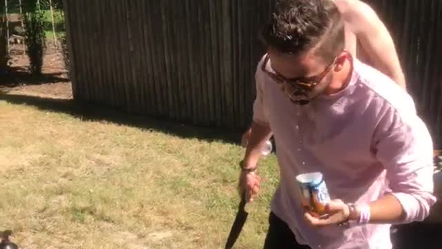 Guy pink shirt opens beer with knife