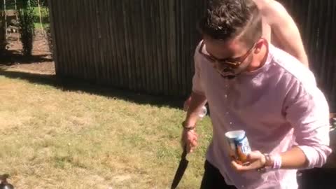 Guy pink shirt opens beer with knife