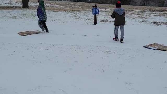 Boys trying to play in the snow