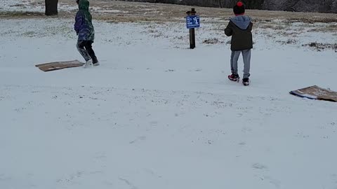 Boys trying to play in the snow