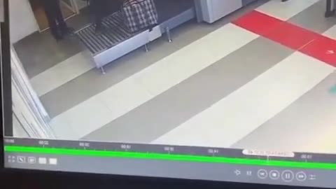 dude goes through the baggage check machine with his luggage.