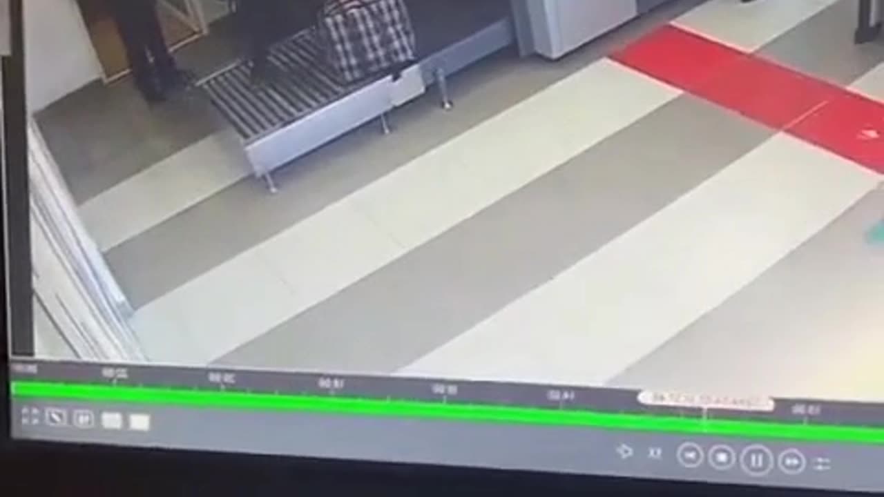 dude goes through the baggage check machine with his luggage.