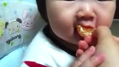 Video of a 2-year-old baby eating tangerine for the first time