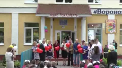 Parents dance with school graduates.