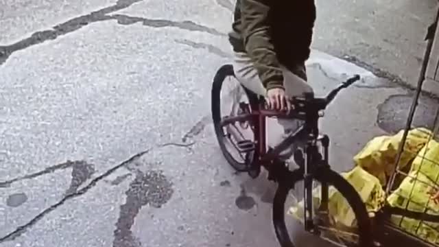 Security camera clip of guy riding bike, falling