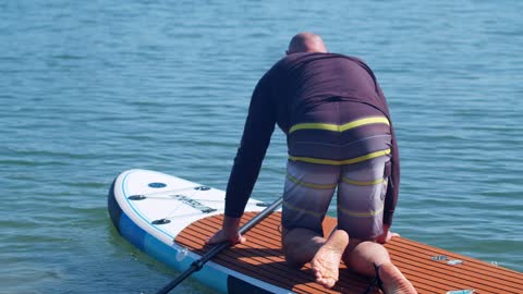 A Man Paddle Boarding In The Harborsurface