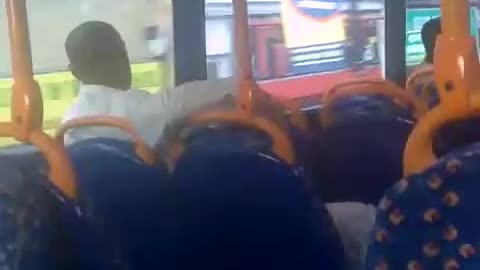 Black dude in all white laughing on bus