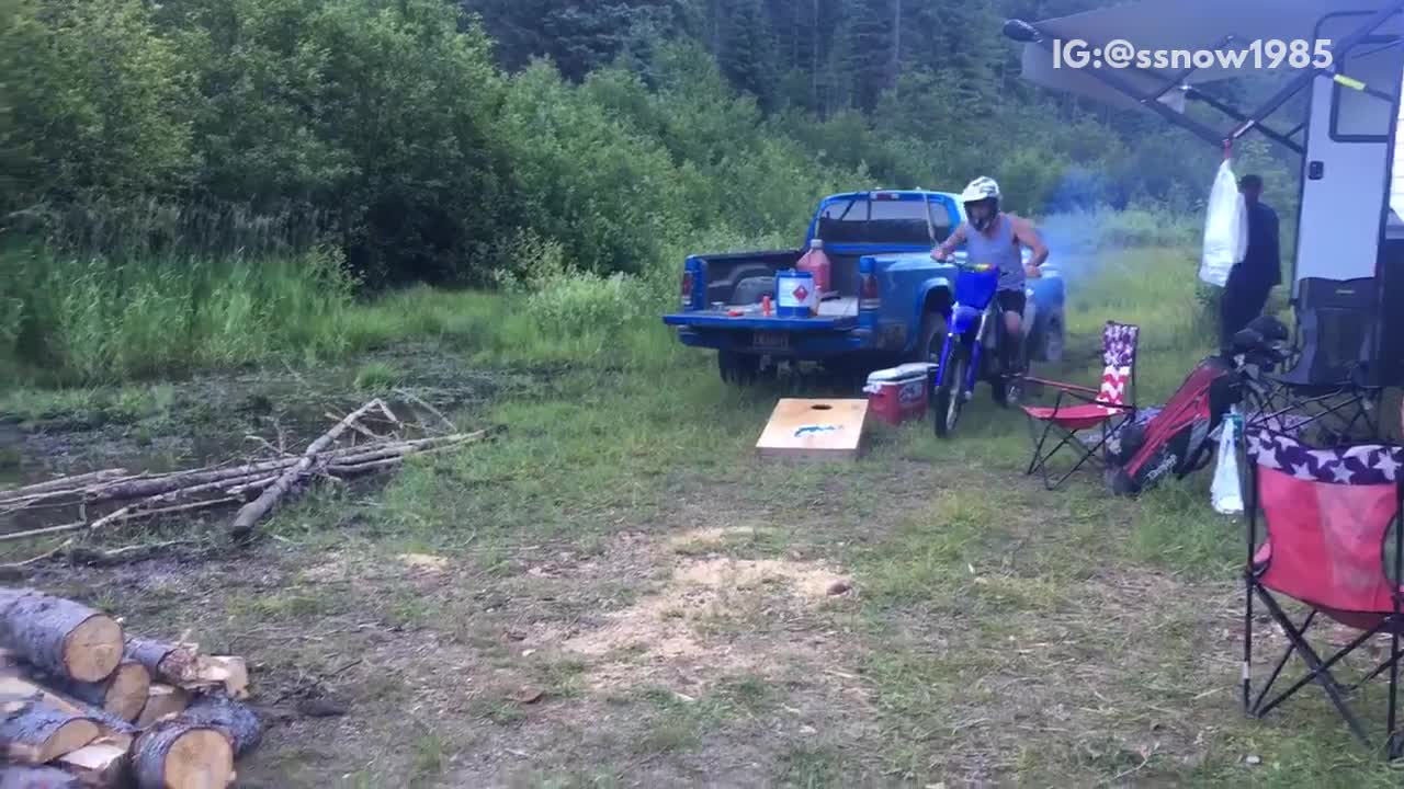 Man in blue motorcycle rides over bon fire