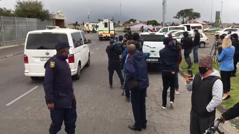 Community and media watch the removal of the accused in a “Nyala”