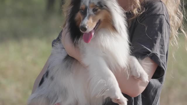 Woman Carrying and Kissing the Dog