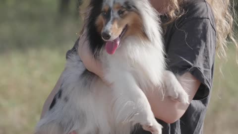 Woman Carrying and Kissing the Dog