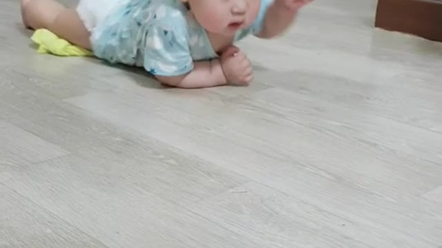 This is a video of a baby crawling hard towards its mother.