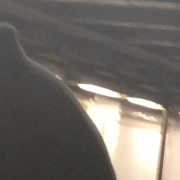 Guy vape juul on neck white earbuds waiting for train