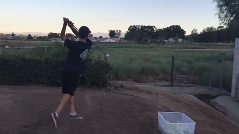 Toss ball over shoulder, spin around and hit with a golf club.