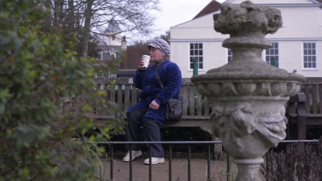 Elderly young woman drinking straw in a garden