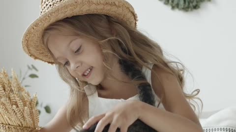 Low angel shot of a girl sitting on bed with a cute cat