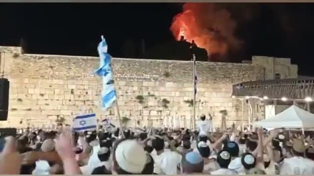 Israelis celebrate as trees in front of Al-Aqsa mosque are set on fire.