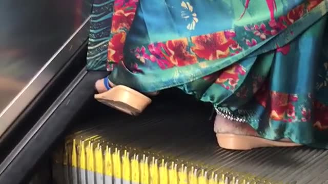 Floral dress sandals dragging food on escalator brushing