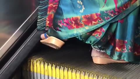 Floral dress sandals dragging food on escalator brushing