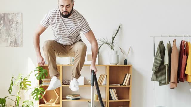 Stop Motion Video of a Man Using a Vacuum Cleaner while Floating on Air