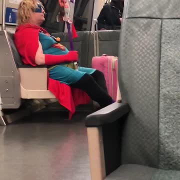 Man dressed as superman on train