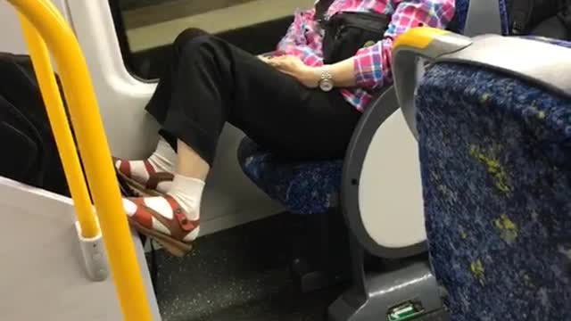 Old woman rubs belly on bus at night