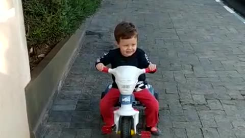 Adorable kid learns to ride trycicle