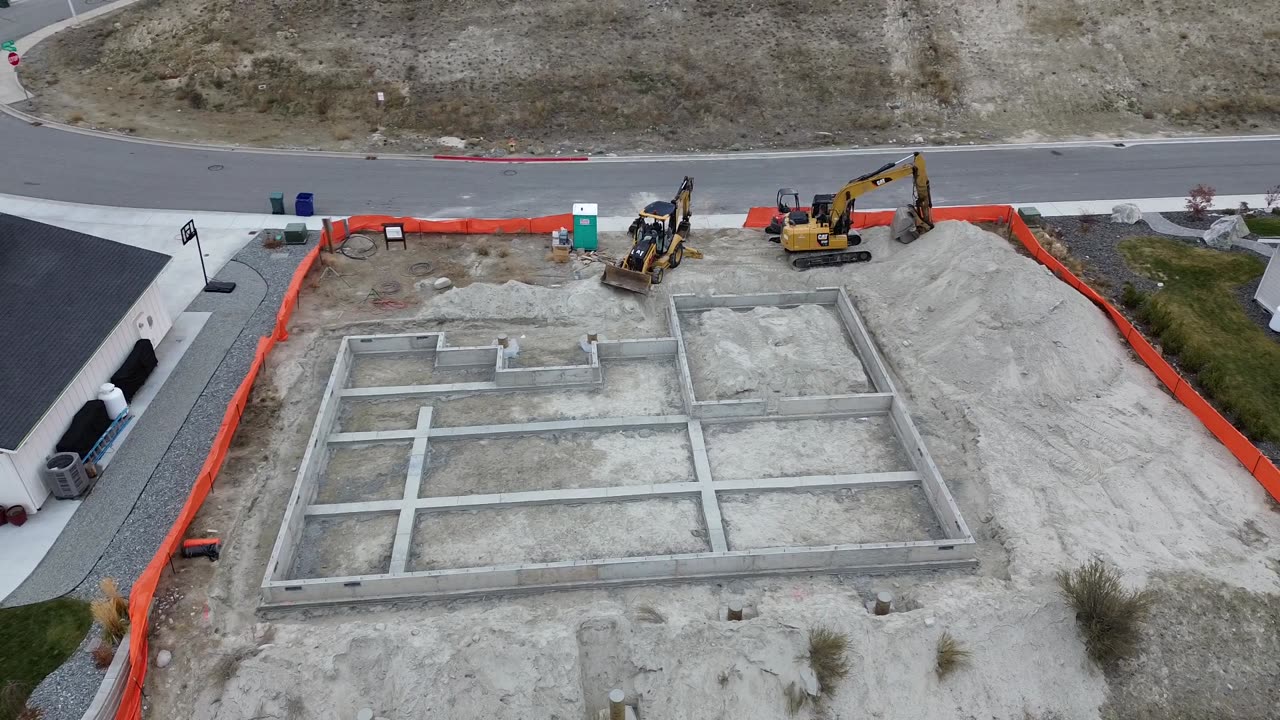 Land clearing, retaining wall, and concrete foundation.